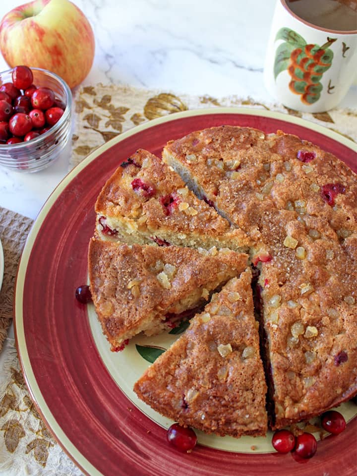 Cranberry apple ginger cake sliced on a red plate. 