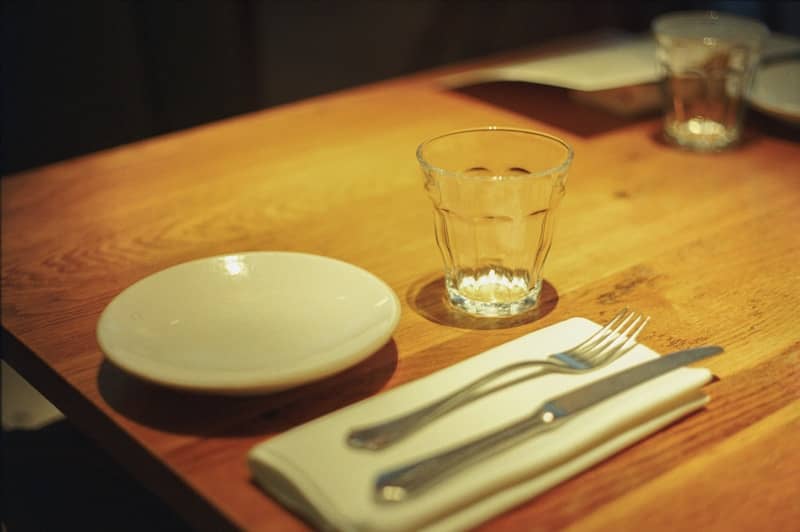 A table set with a plate, glass, and cutlery.