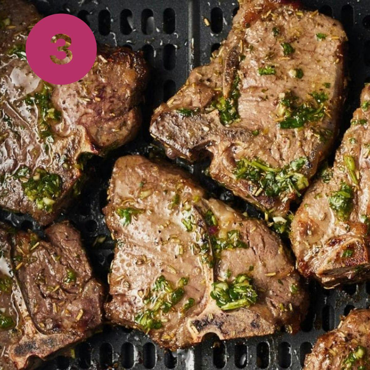 cooked lamb chops in air fryer basket top with chimichurri