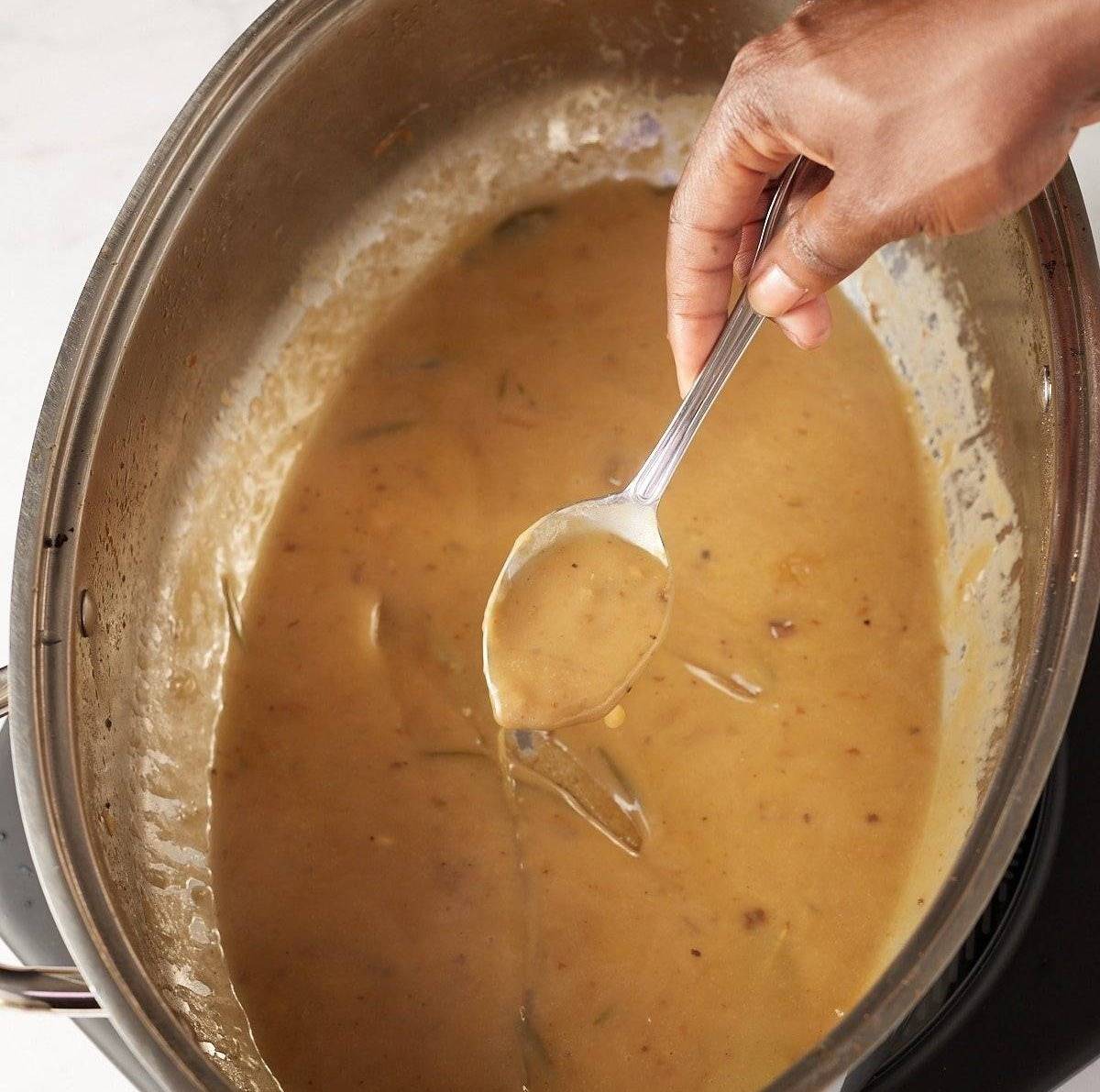 spoon picking up gravy from pan