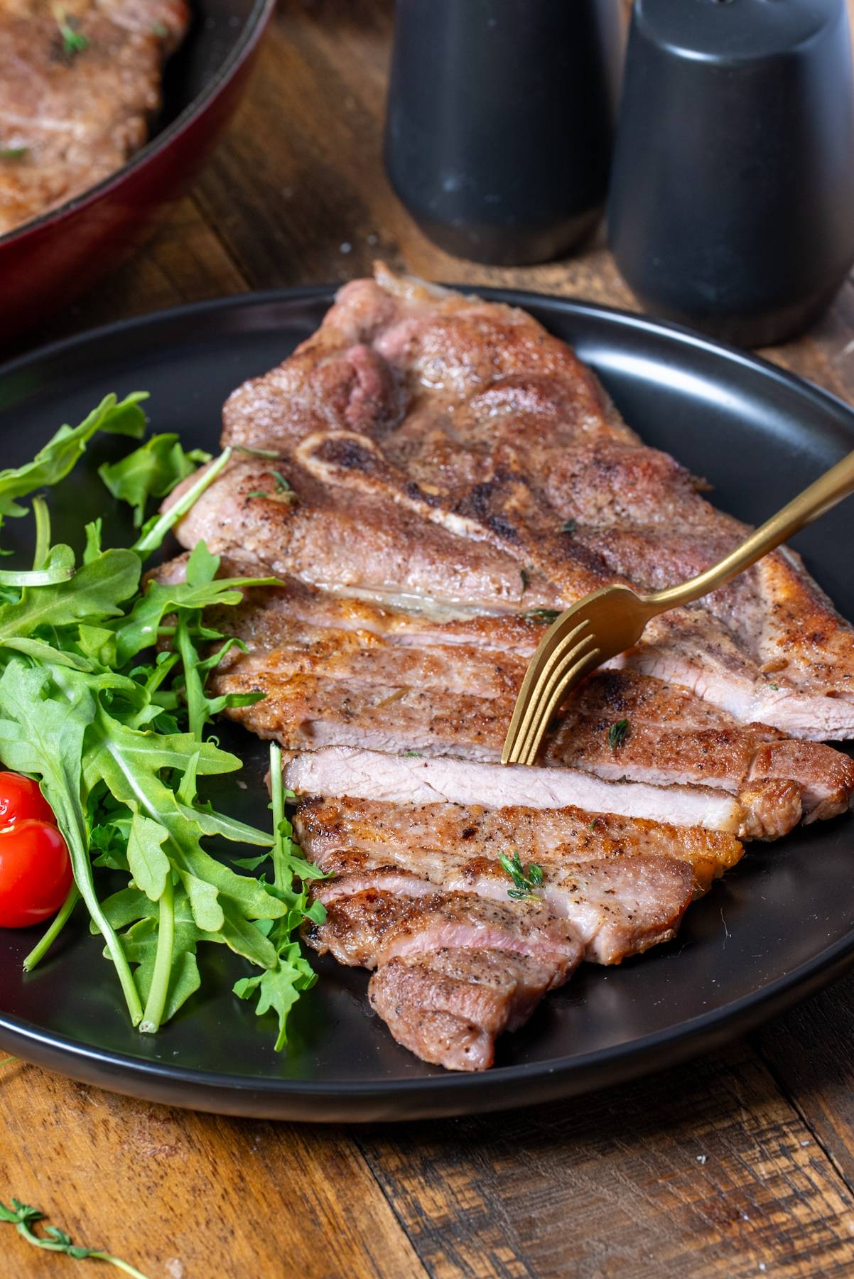 cooked pork shoulder steak sliced on plate
