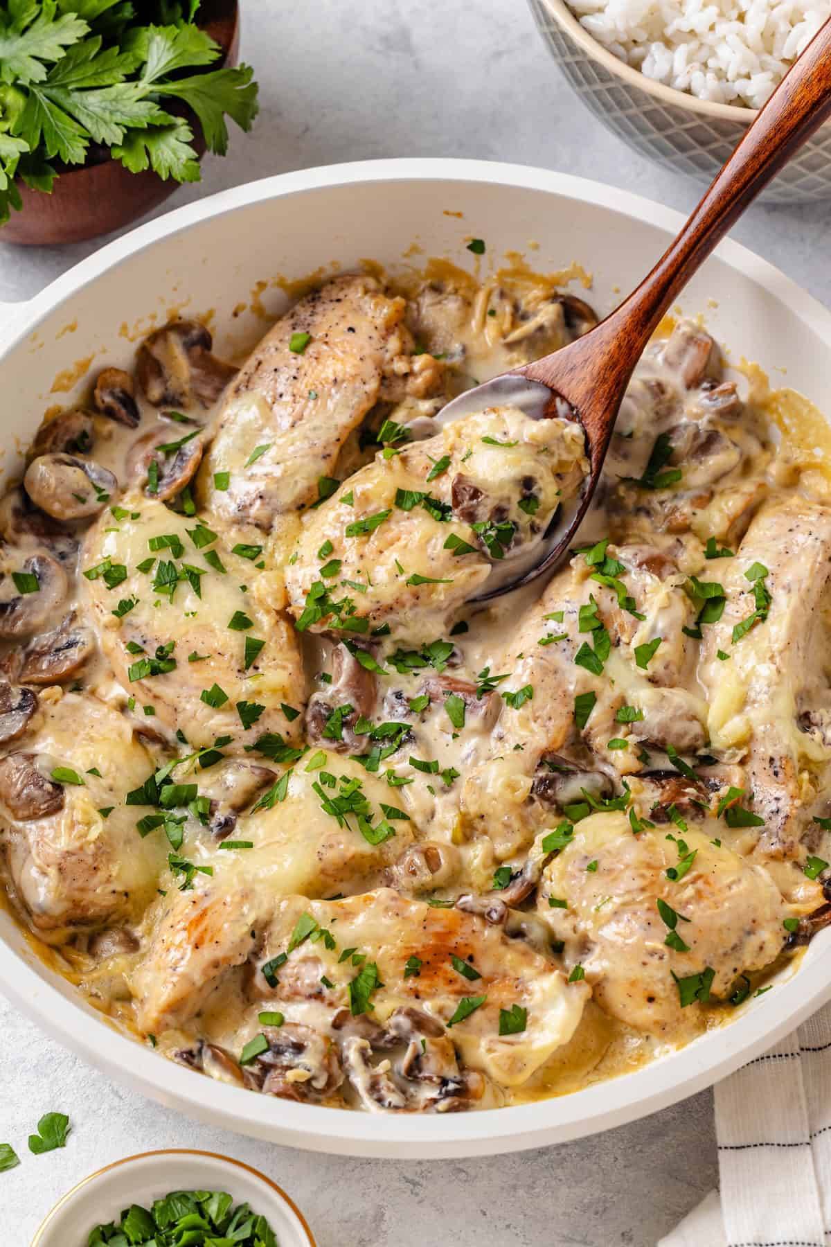 cream cheese chicken in skillet with spoon picking it up