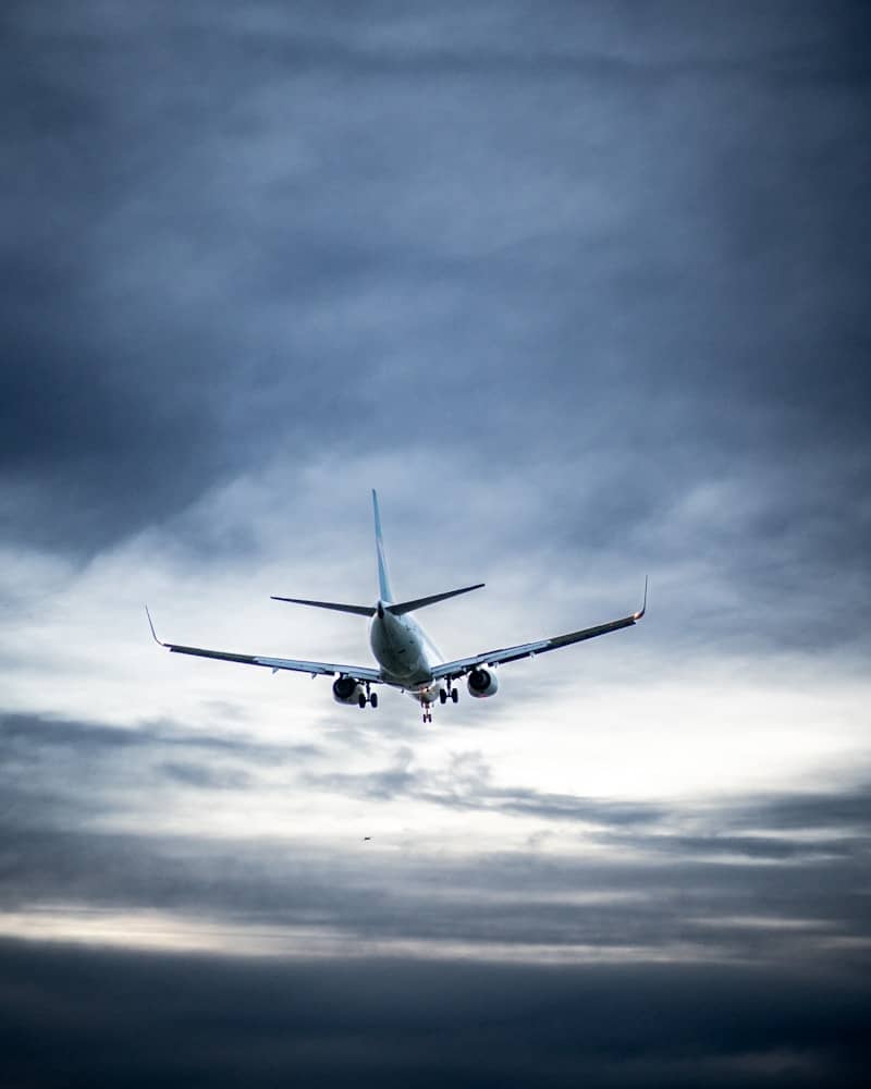 Airplane flying through cloudy sky.