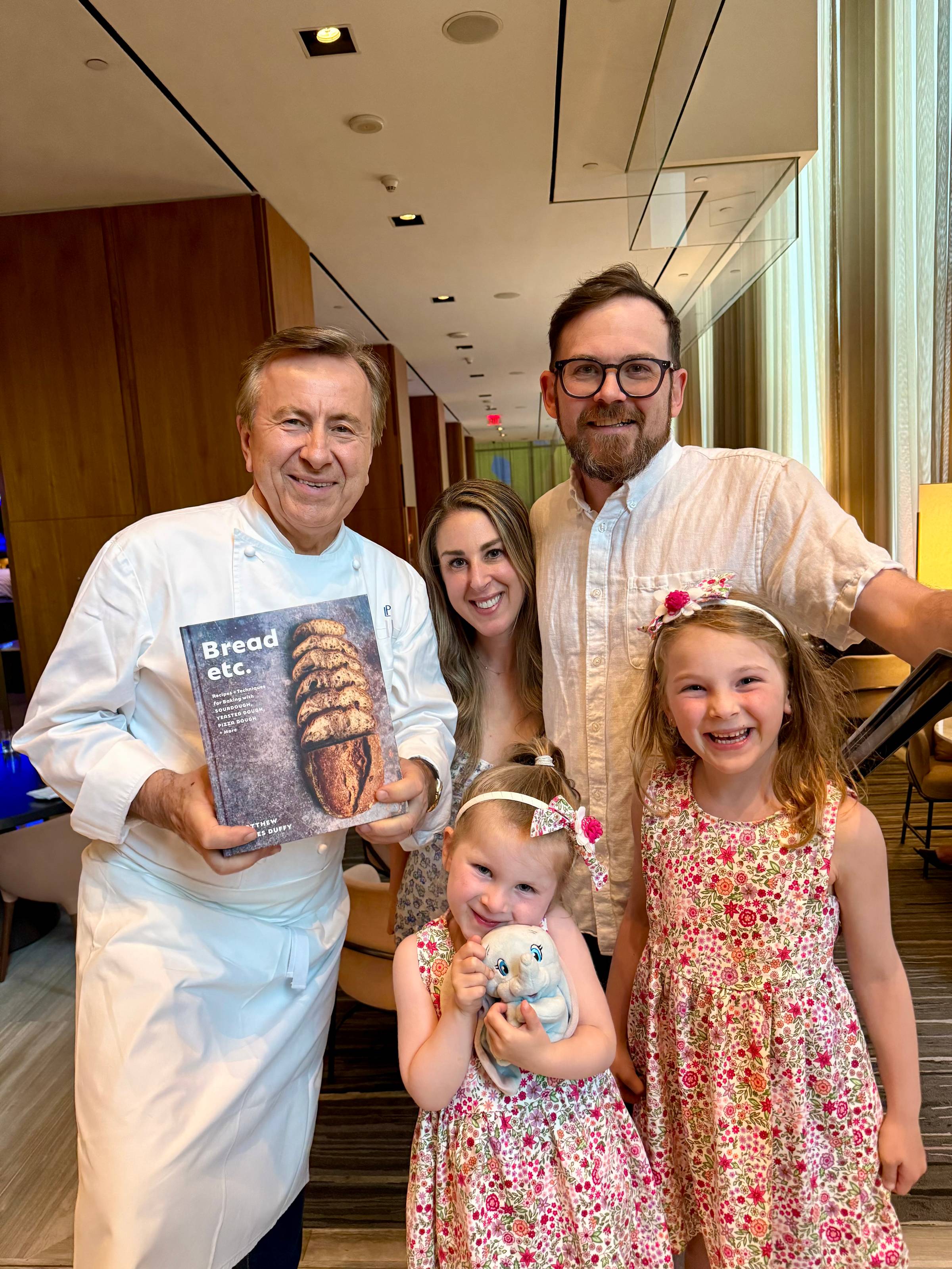 matthew duffy with his family and chef daniel boulud holding his book Bread Etc. 