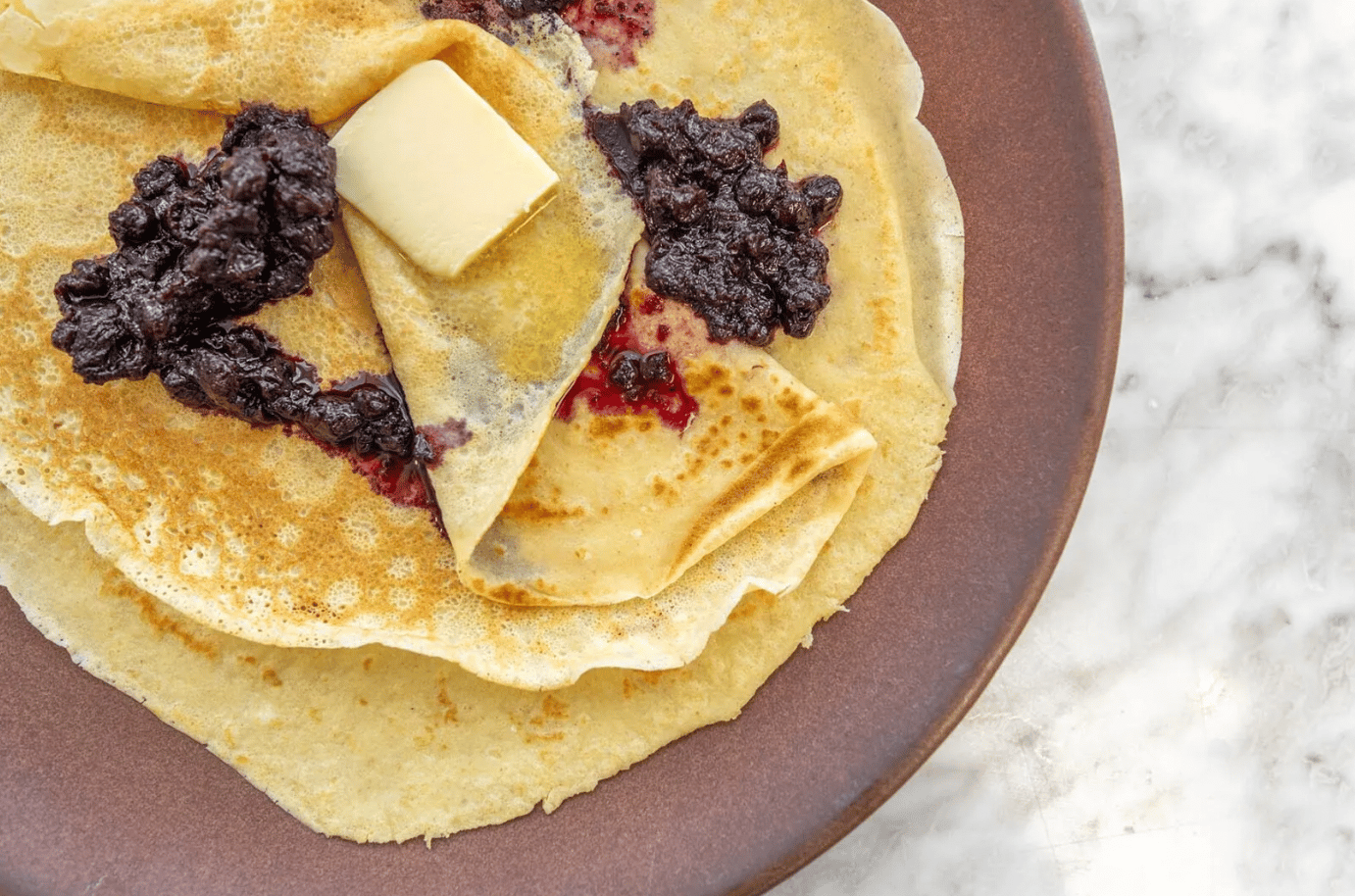 sourdough crepes with blueberries and butter melting on top