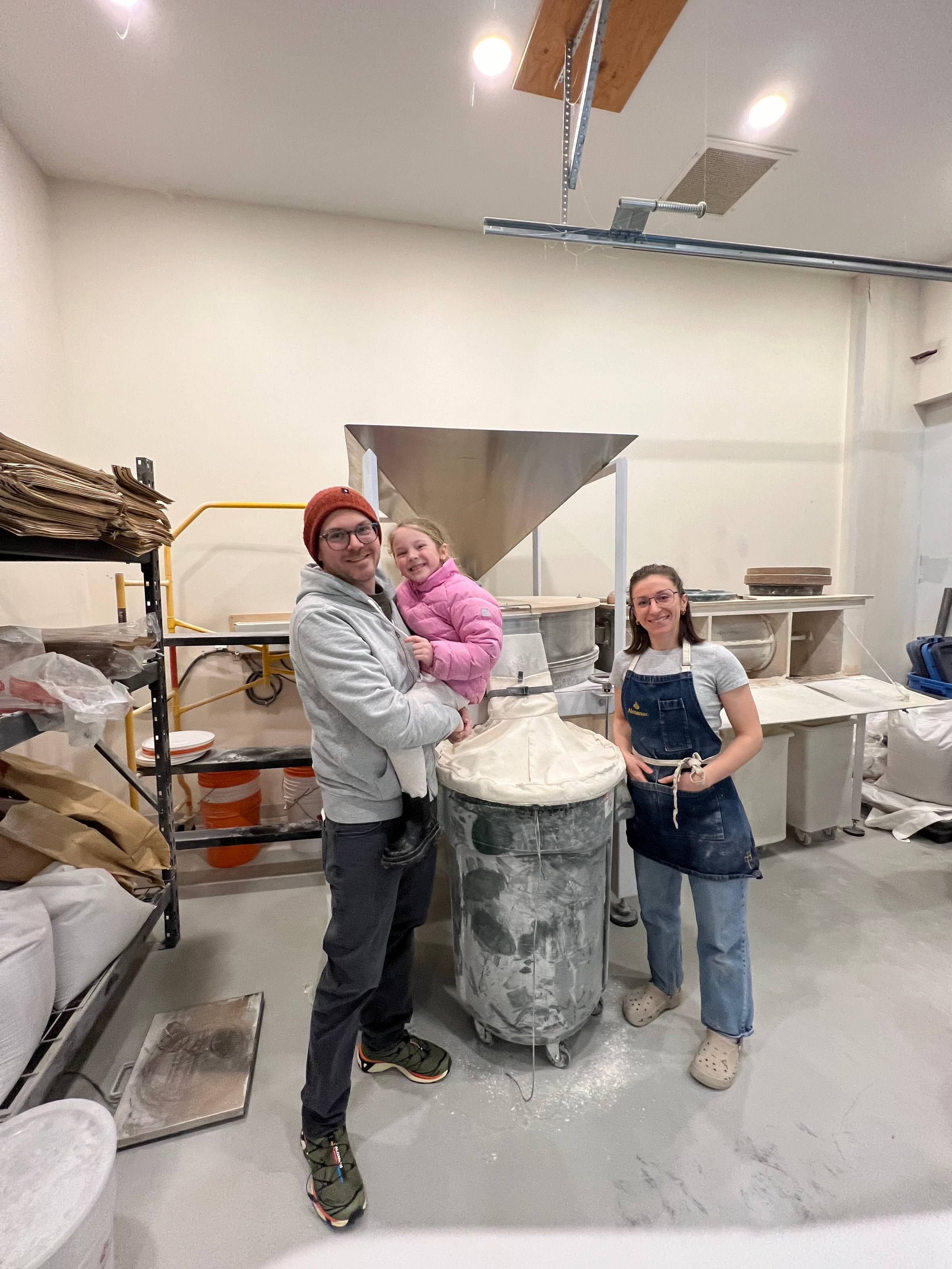 me juniper and gabby in front of a large stone mill at almanac bakery