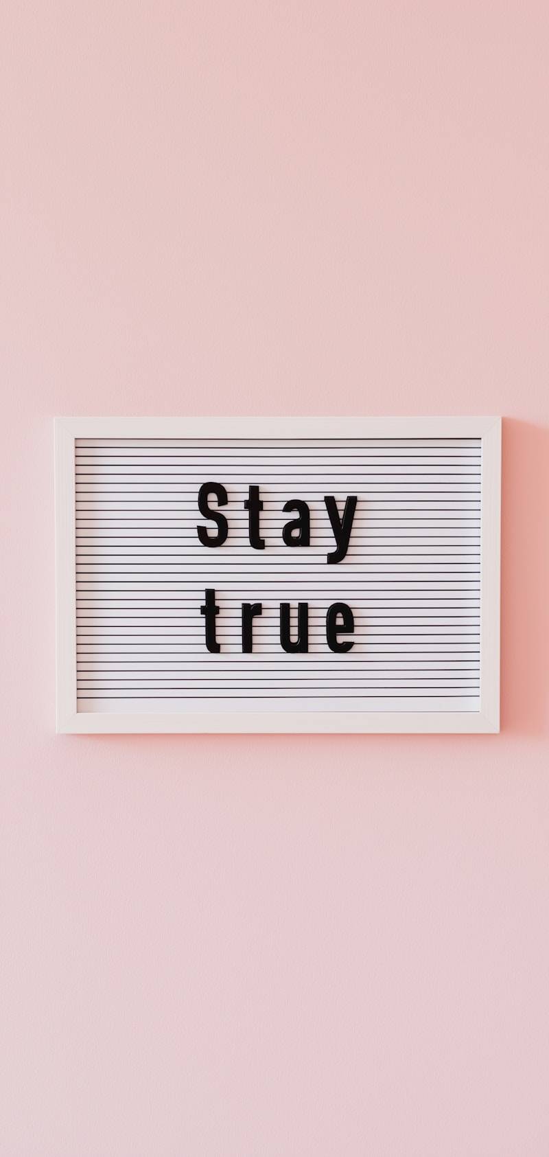 Letter board with "stay true" message on pink background