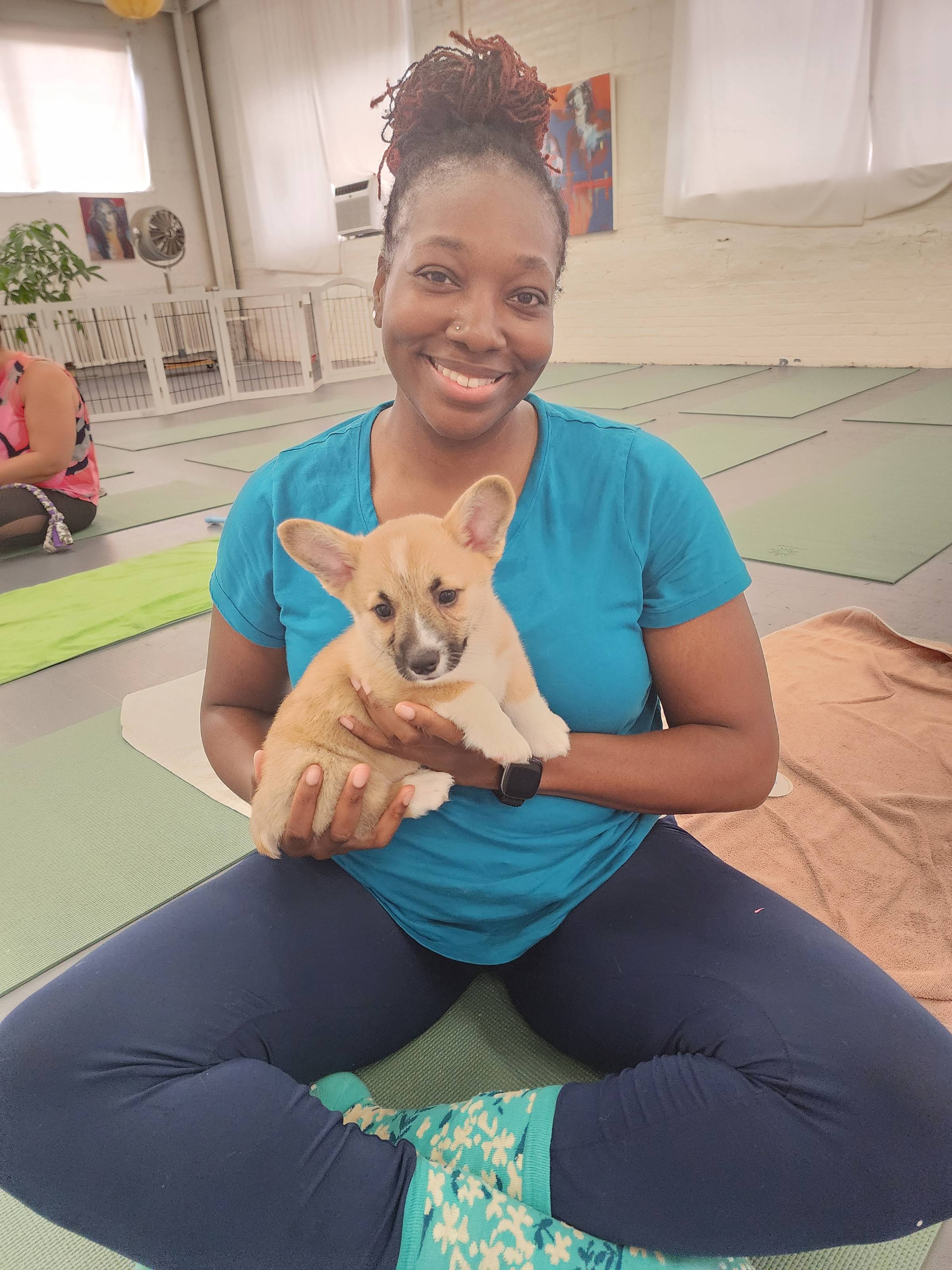 Smiling woman holding puppy during wellness class