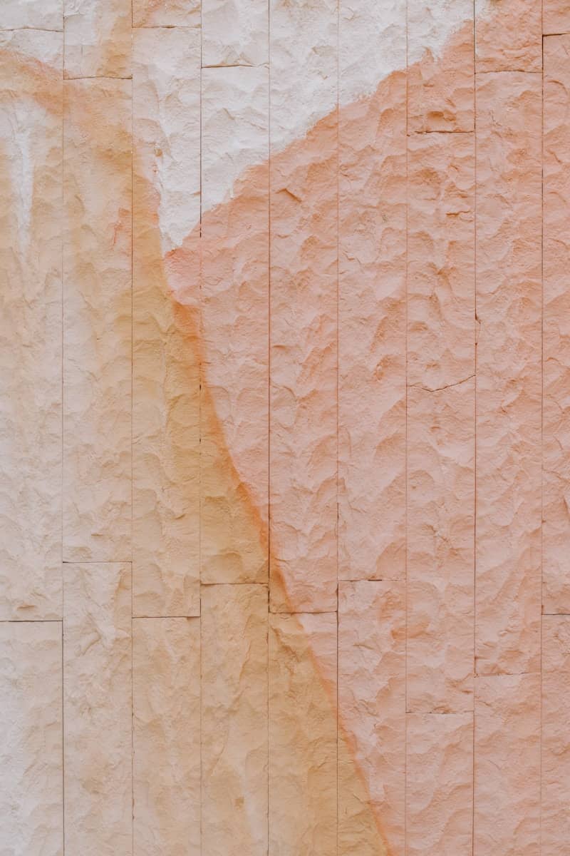 Textured stone wall with orange and white streaks
