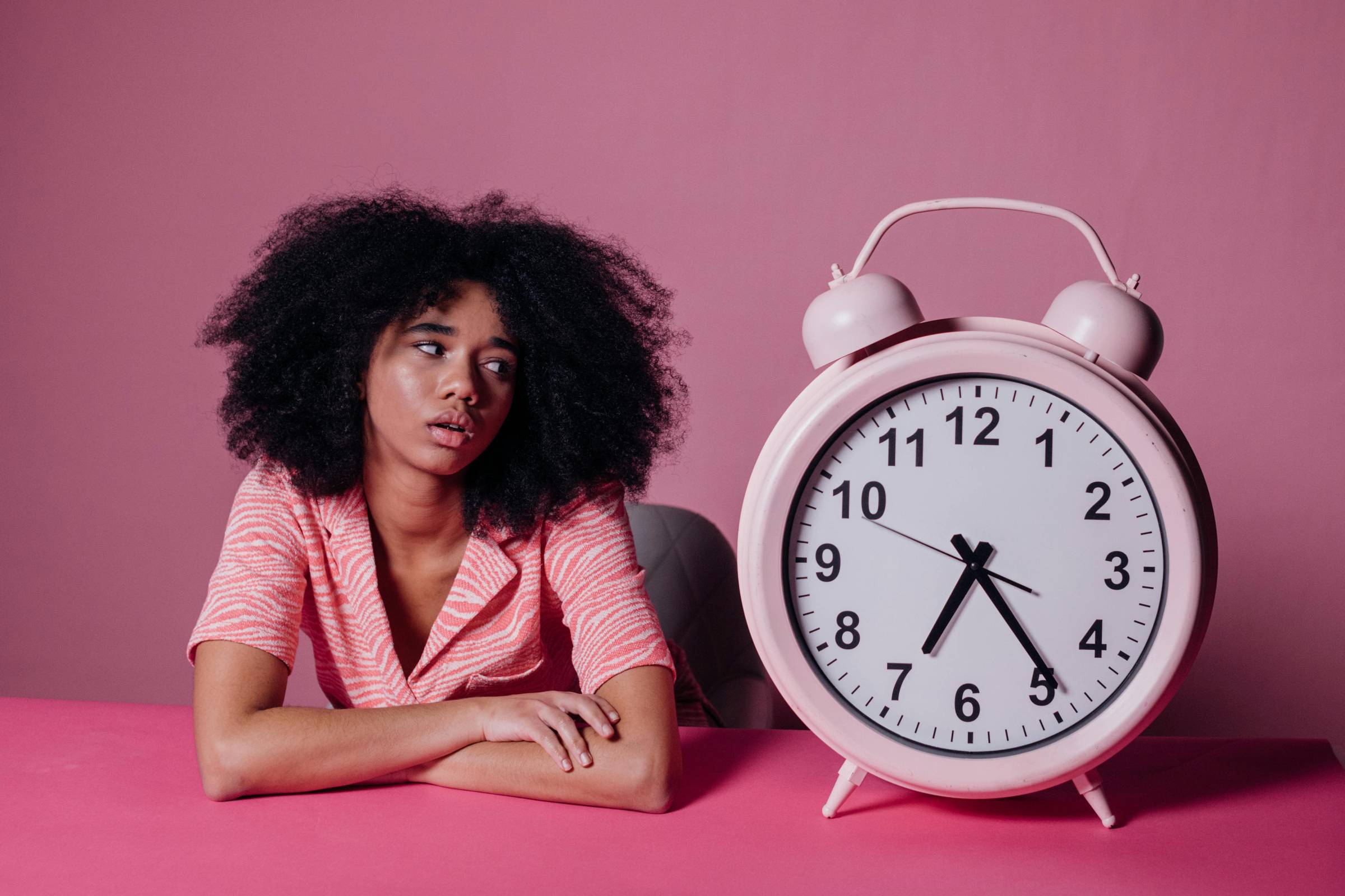 a black woman staring at a clock waiting
