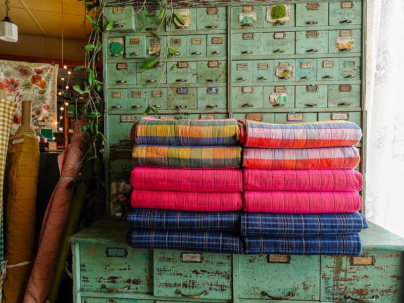 stacks of jacquard on a vintage green cabinet
