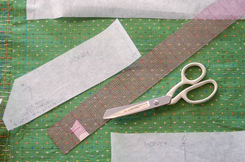Green cross stitch fabric with scissors and ruler