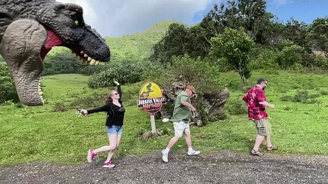 A gif of Sue running from a T-Rex in the jungle