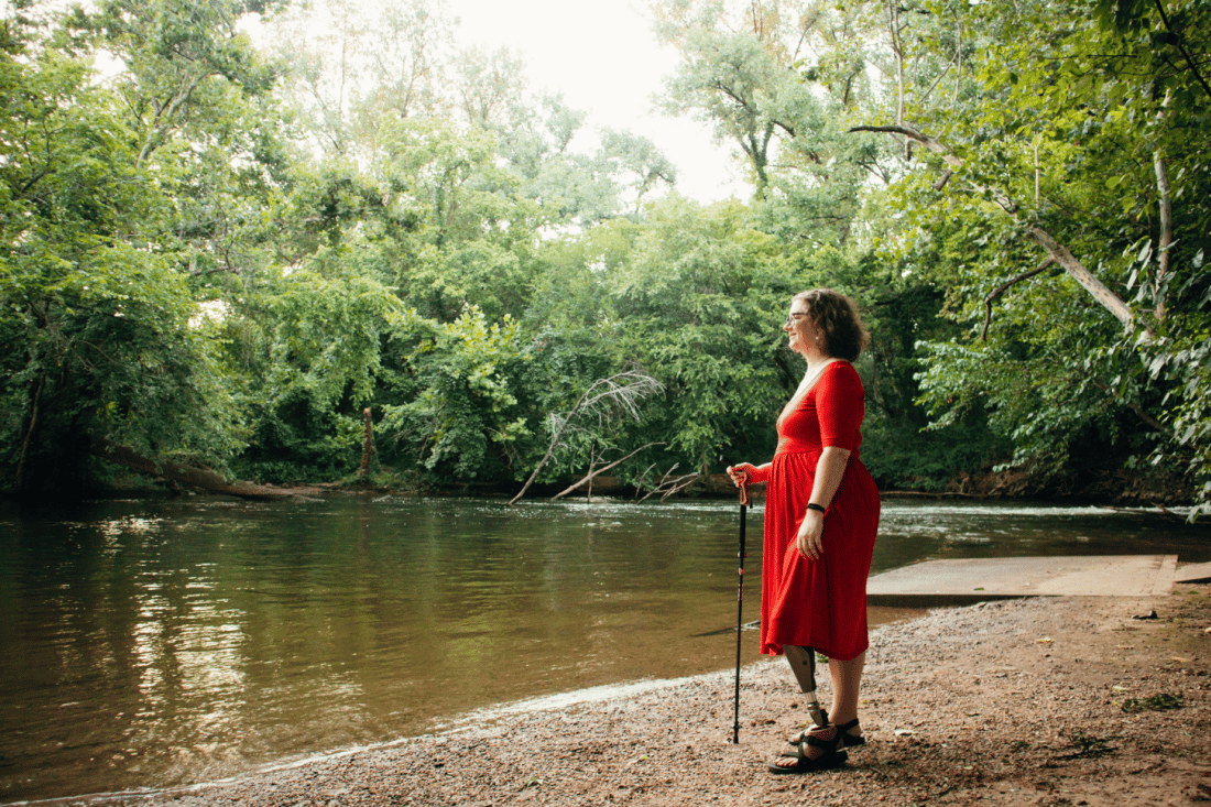 Woman with prosthetic leg at wooded riverbank in Richmond, Virginia
