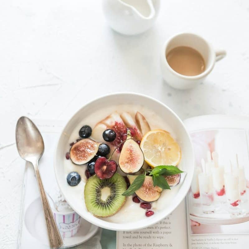 white ceramic plate beside gray steel spoon