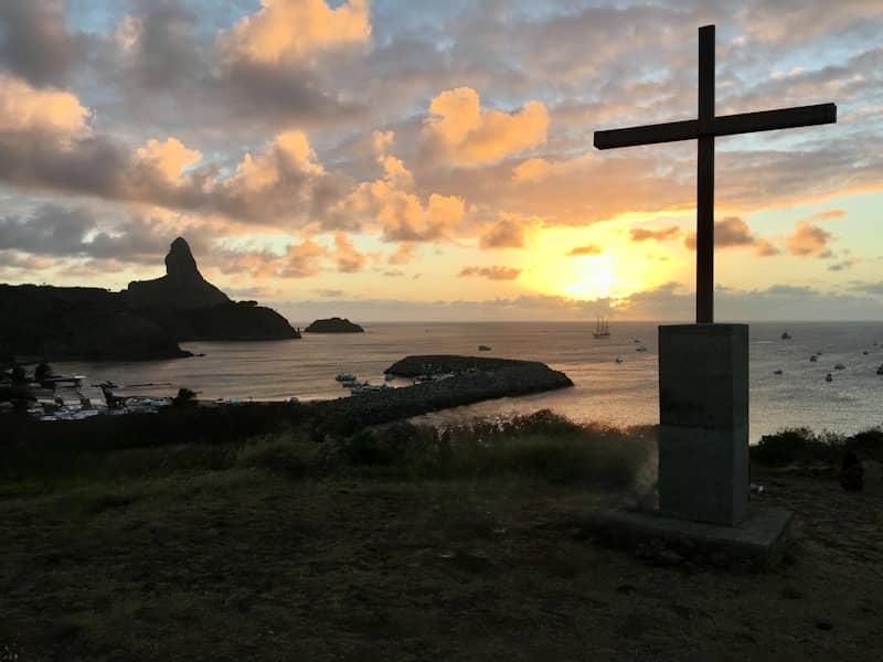 Cross silhouette against a sunset ocean view