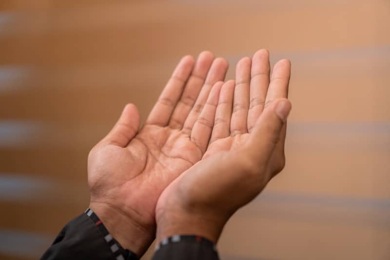 Two hands held open in a gesture of prayer.