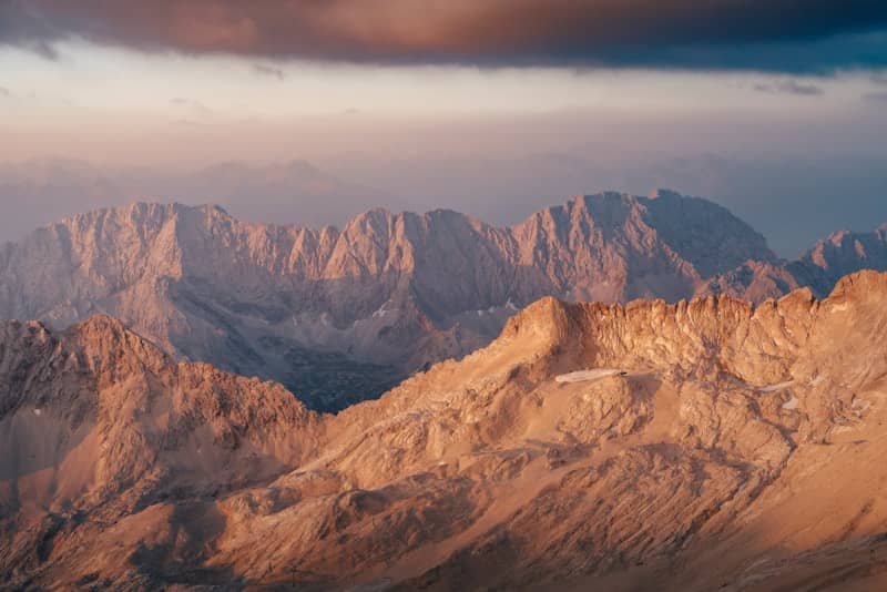 Golden mountain peaks at sunset with dramatic clouds