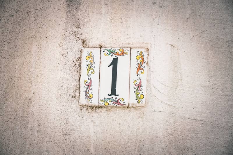 Number one tile on an old, weathered wall.