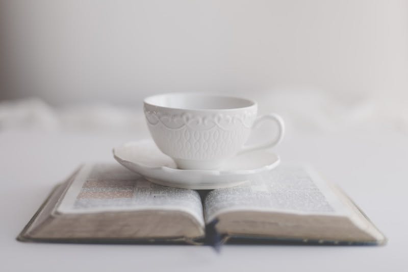 An open book with a cup on top of it