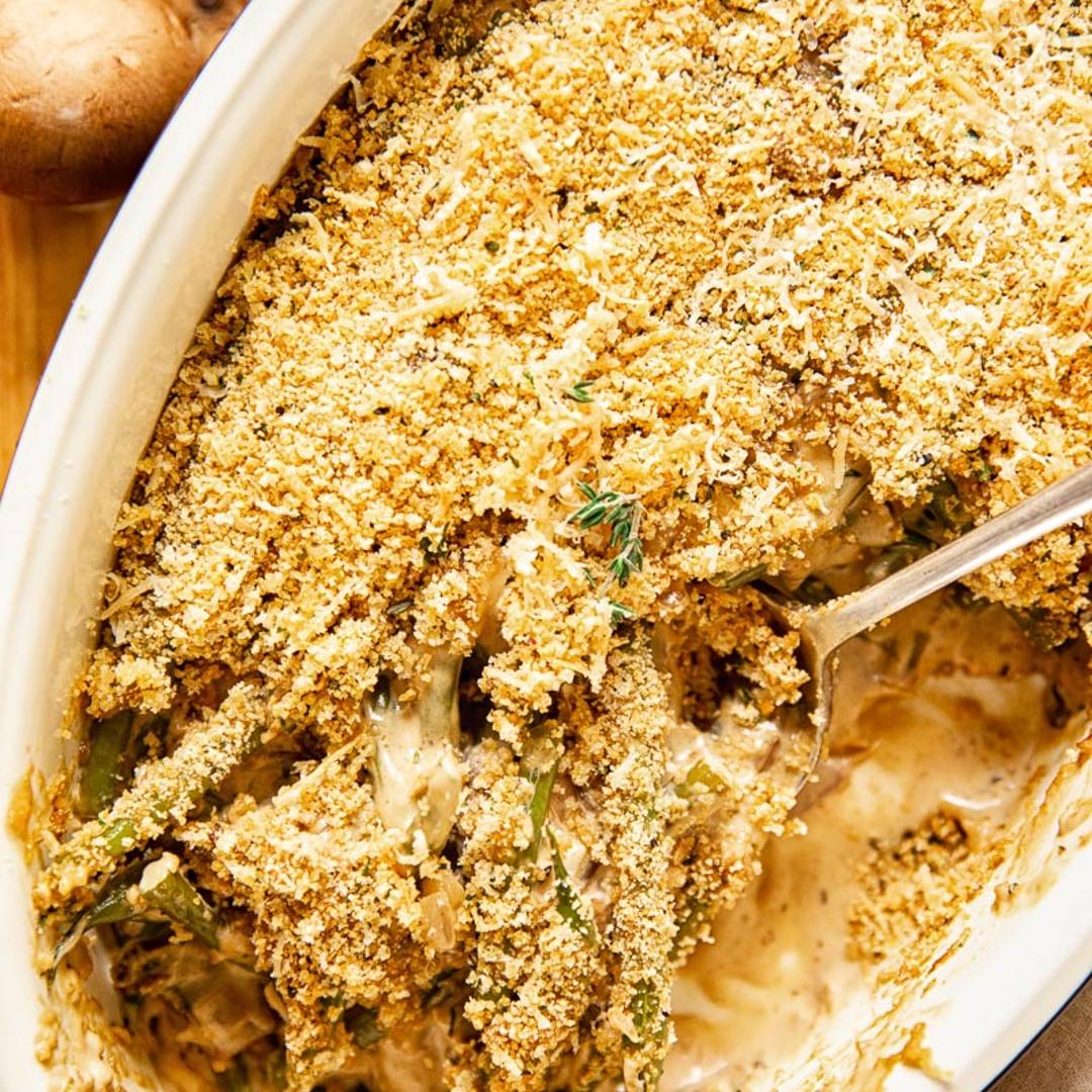 baking dish with green bean casserole, topped with breadcrumbs, and servings removed
