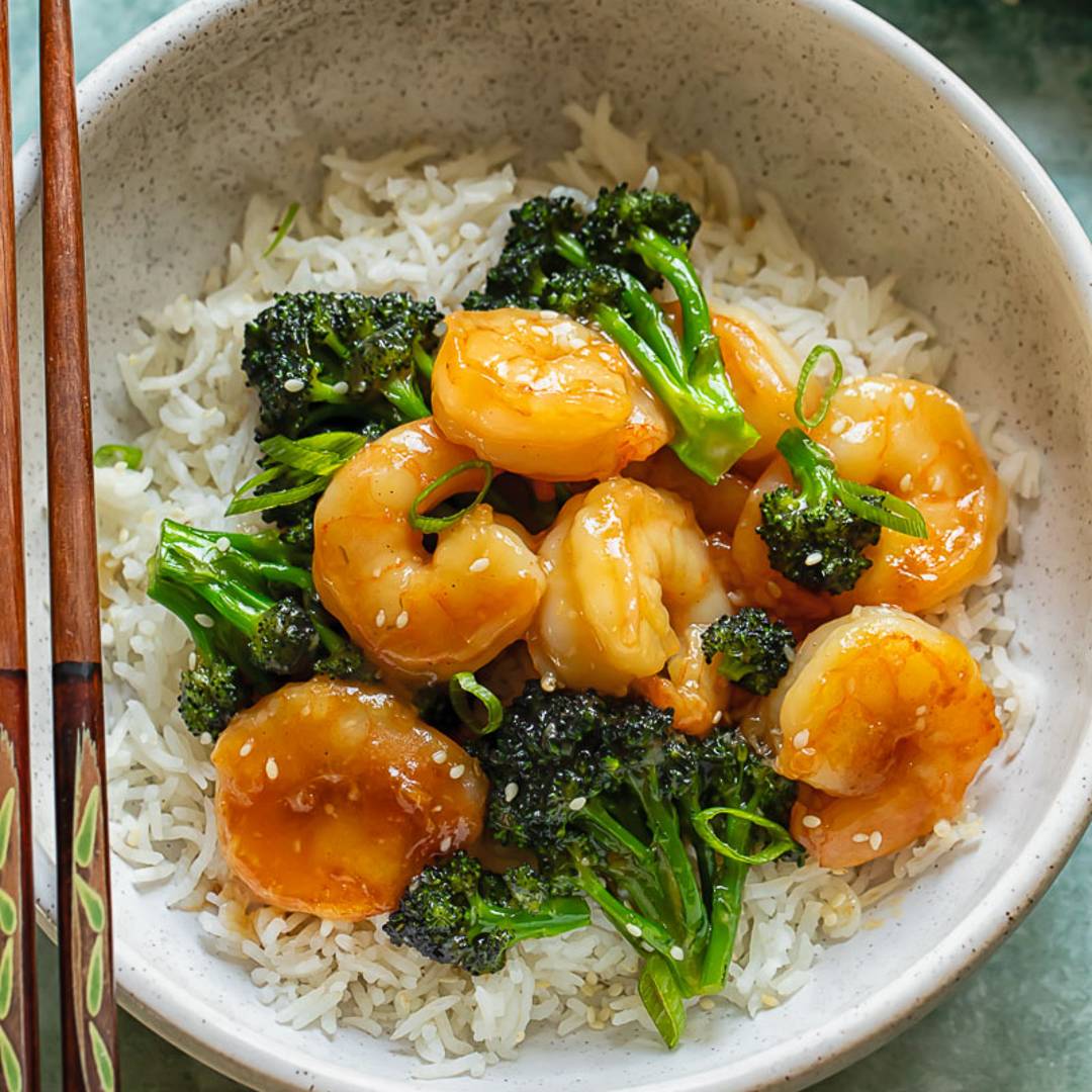 a bowl with shrimp and broccoli on top of white rice