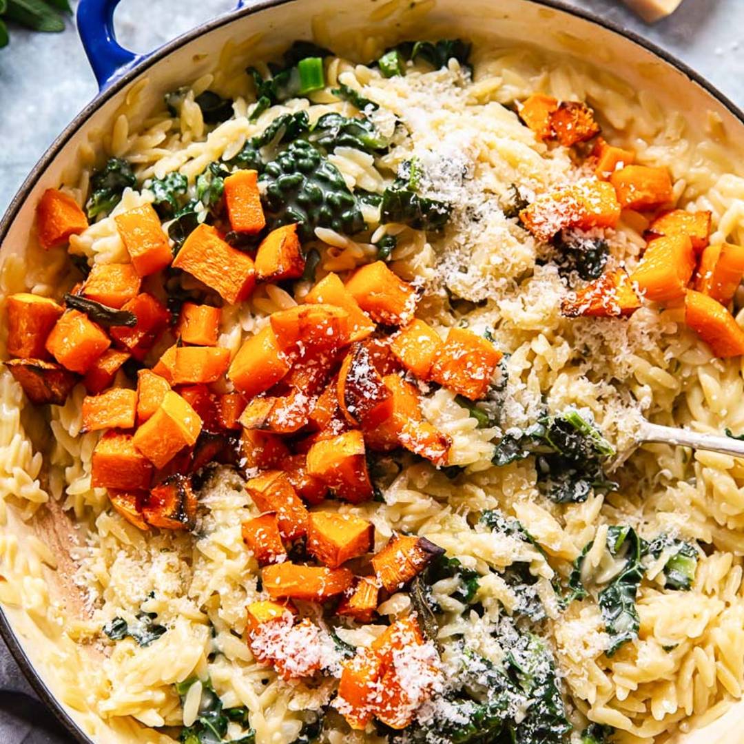pan of orzo with lots of squash, greens and shredded cheese