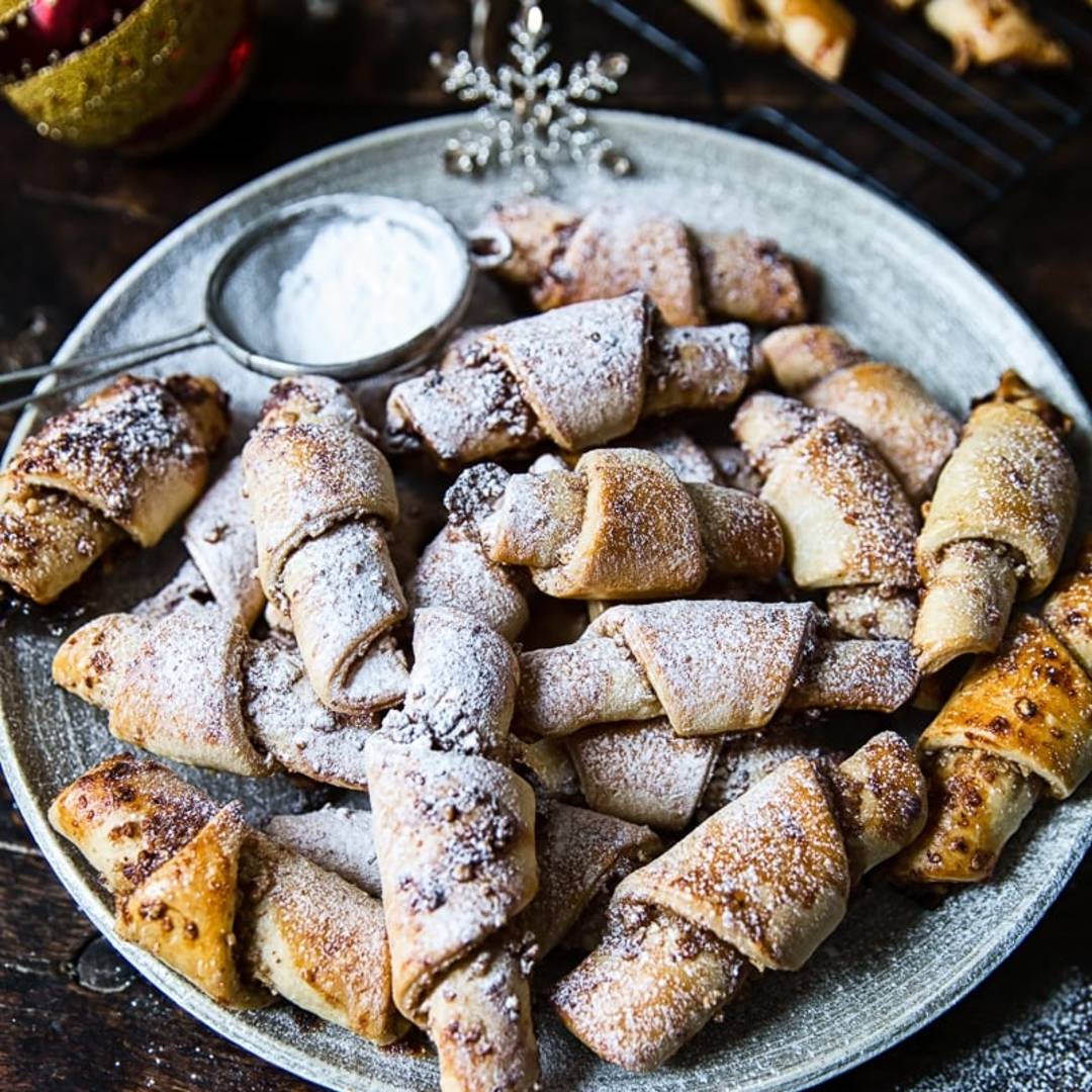 a plate of wrapped cookies with a sprinkling of icing sugar