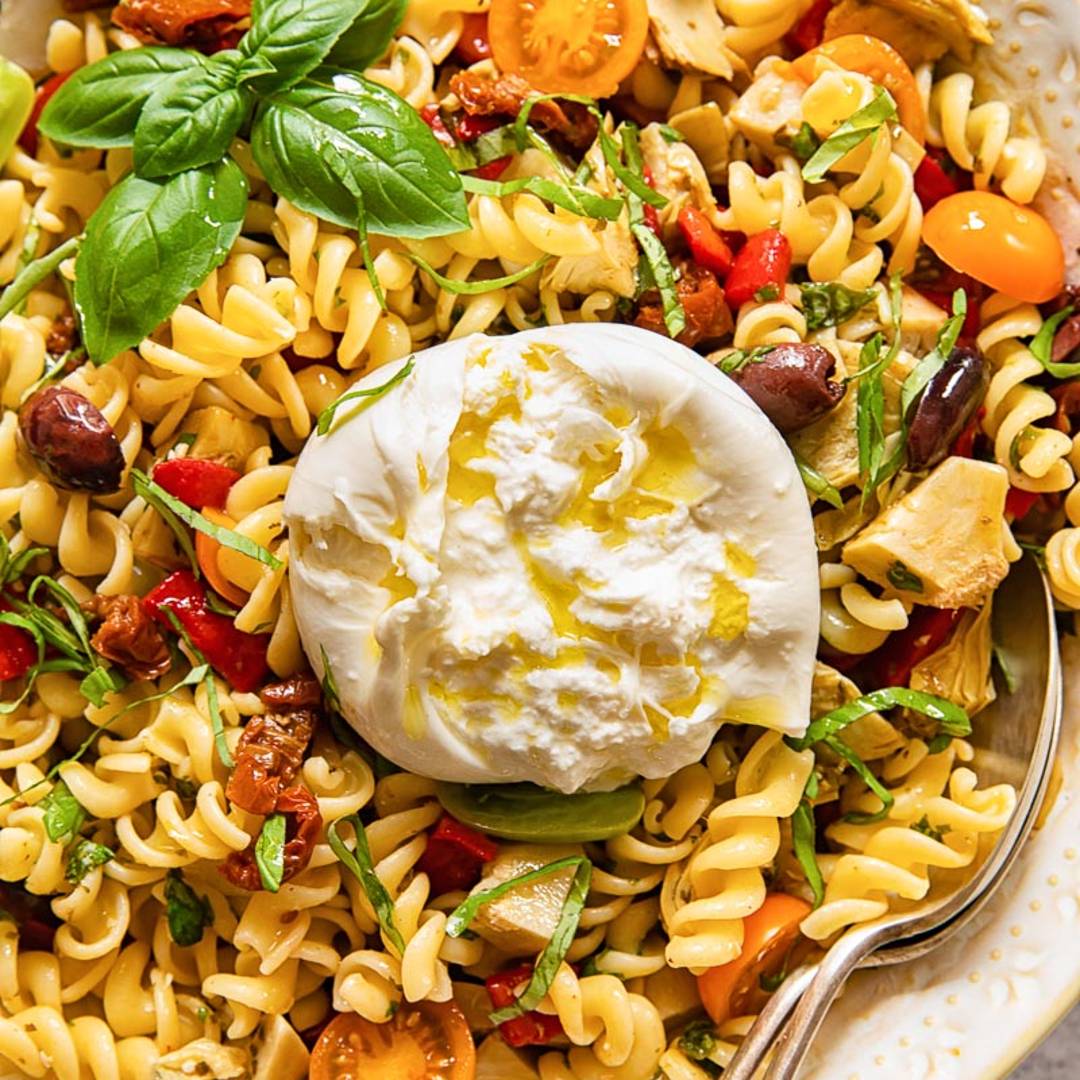 serving dish with pasta salad topped by a round of burrata