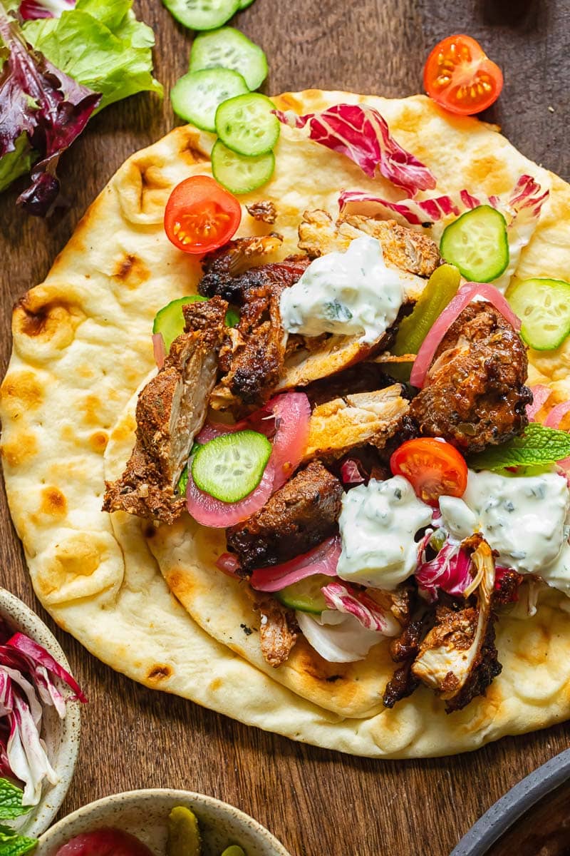 A flatbread filled with chicken, vegetables and a creamy sauce.
