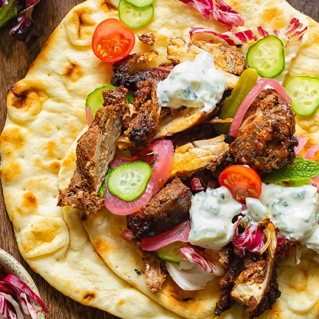 A flatbread filled with chicken, vegetables and a creamy sauce.