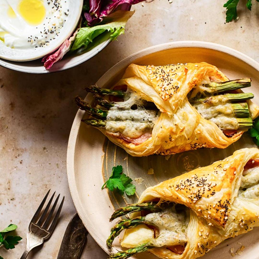 two puff pastry appetizers on plate alongside a dip