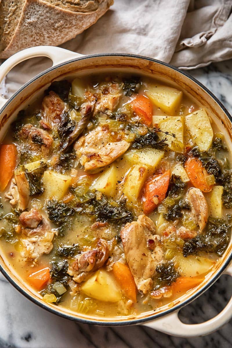 close up of a pot of chicken stew with plenty of vegetables and potatoes showing
