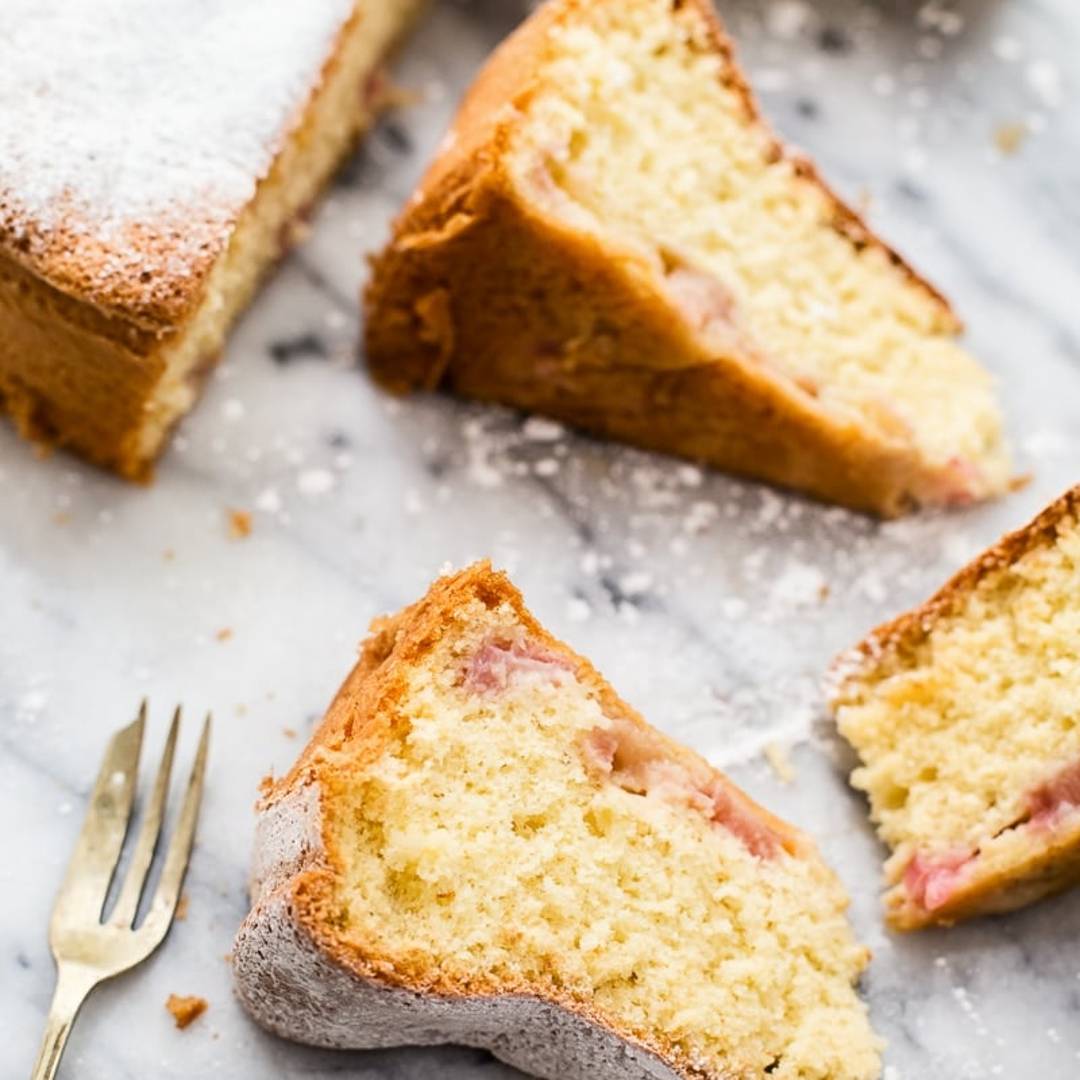 pieces of a soft cake with icing sugar dusting lying on a marble background