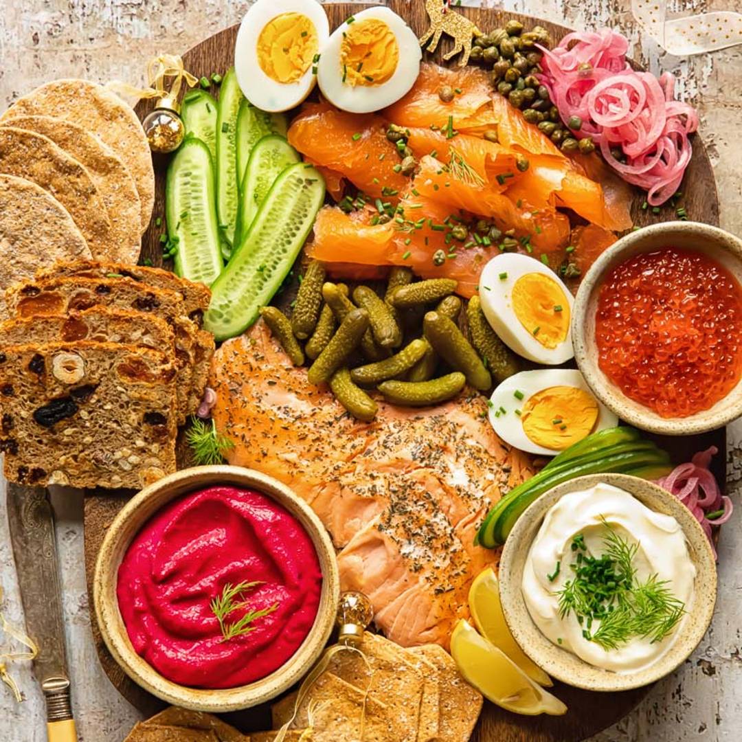 a grazing board with smoked salmon, breads and fresh ingredients