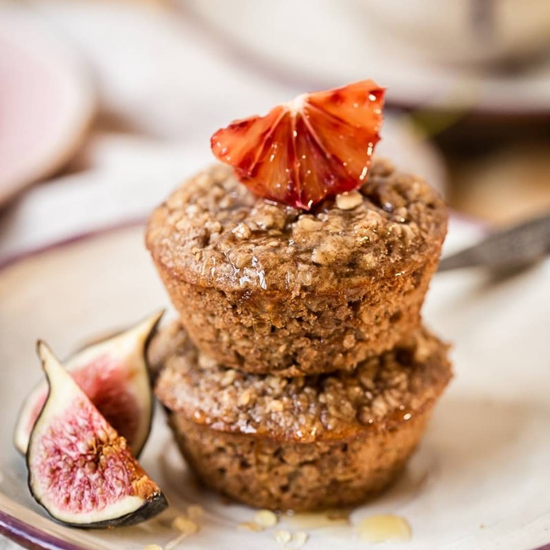 two muffins on a plate with pieces of fruit