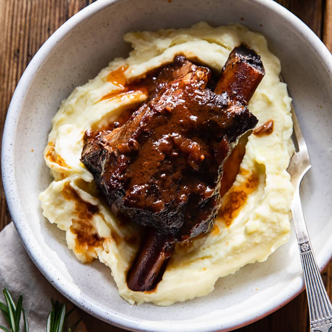 bowl of mashed potatoes with short rib on top