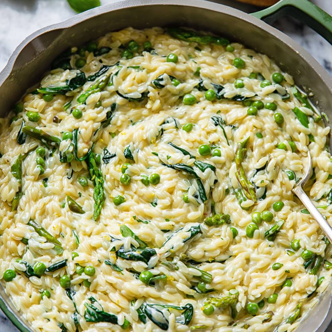 pan with creamy orzo mixed with green vegetables