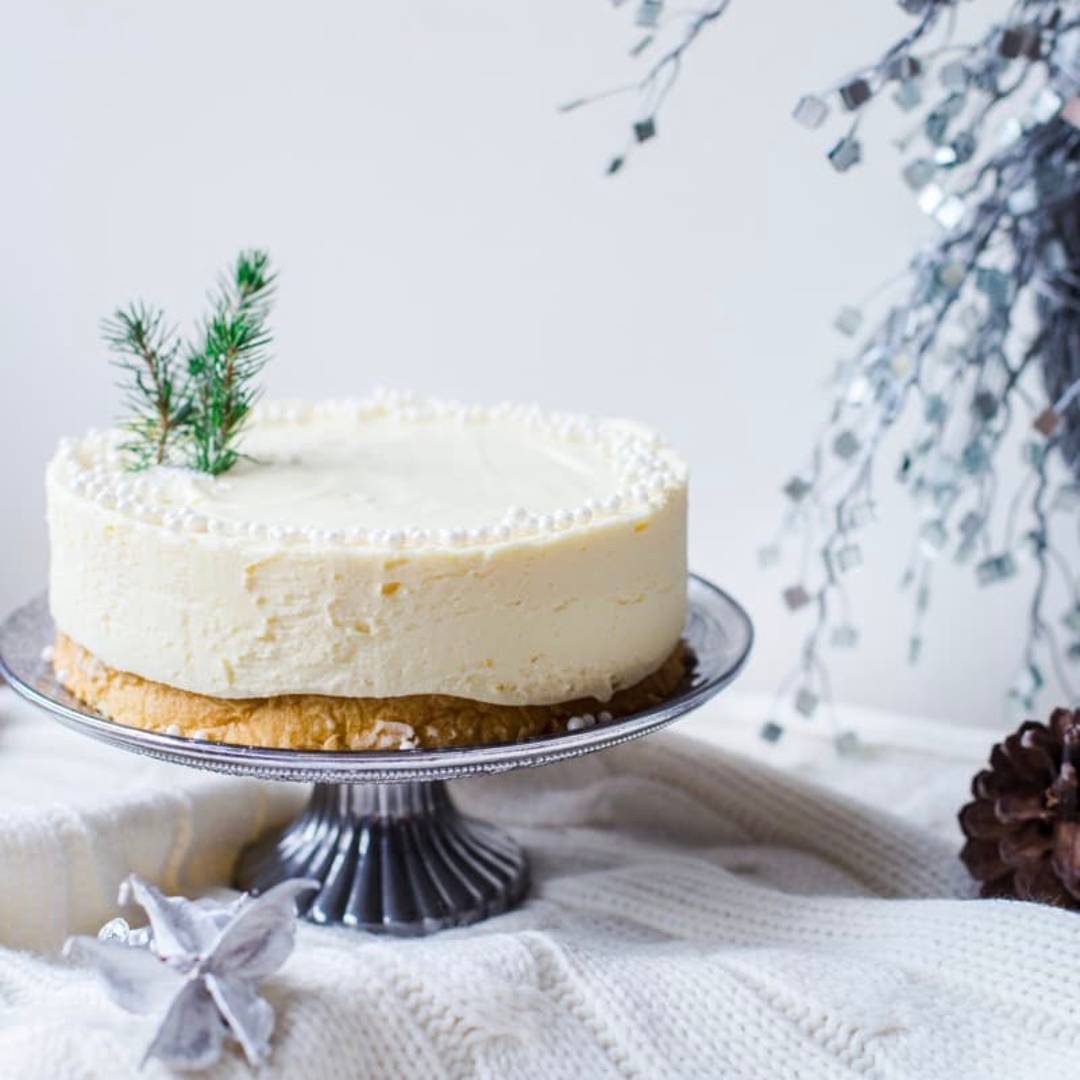 a white cake on a silver platter against a white background
