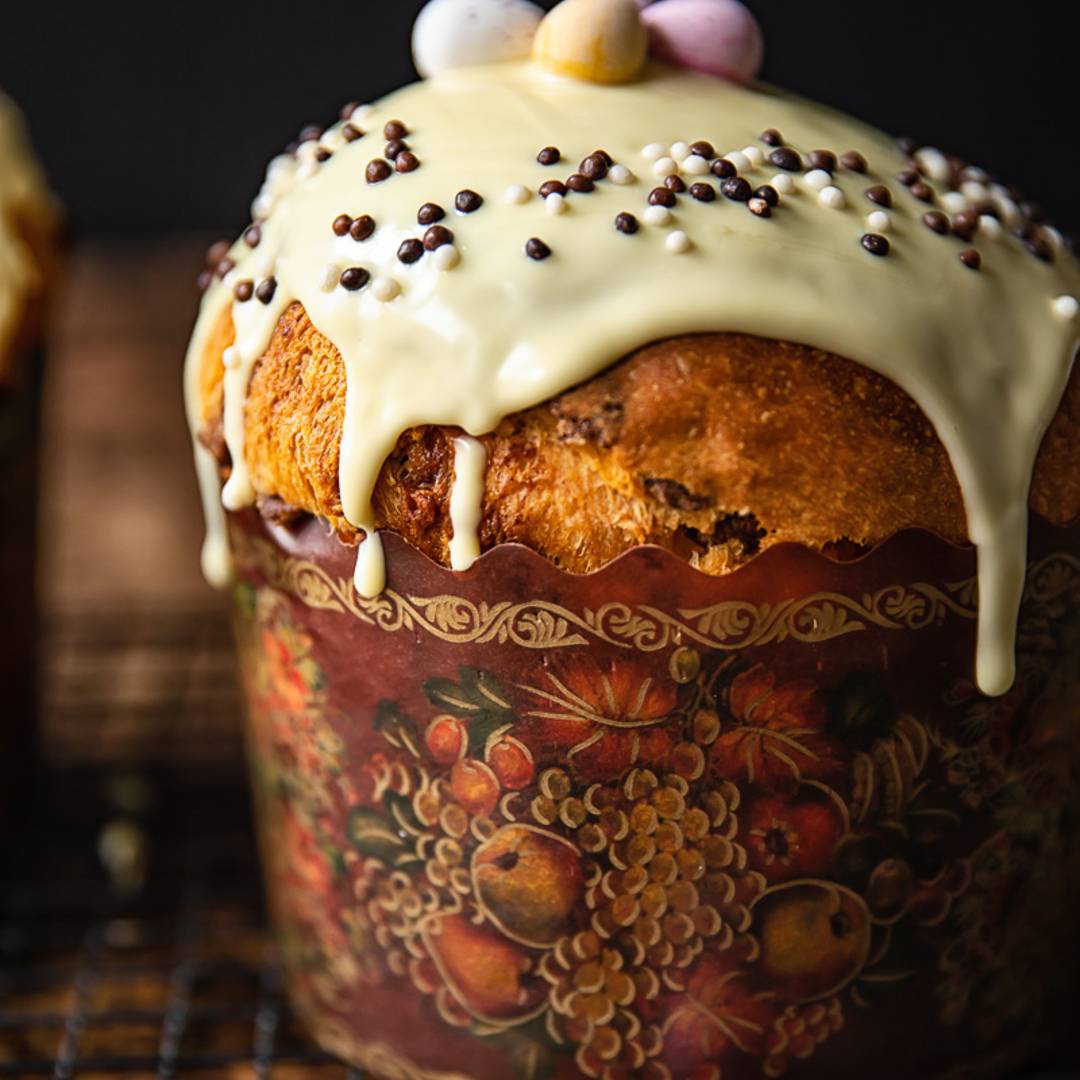 tall loaf with icing in a colourful wrapper, decorated with small Easter eggs