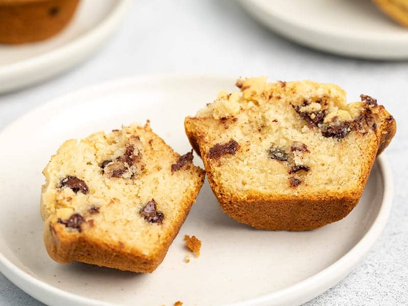 chocolate chip muffin sliced in half on small white plate