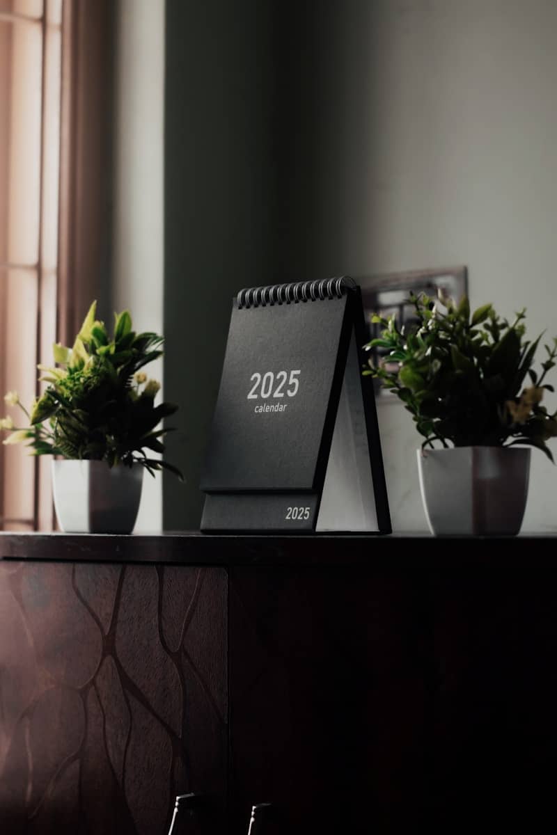 A desk with a calendar and plants on it