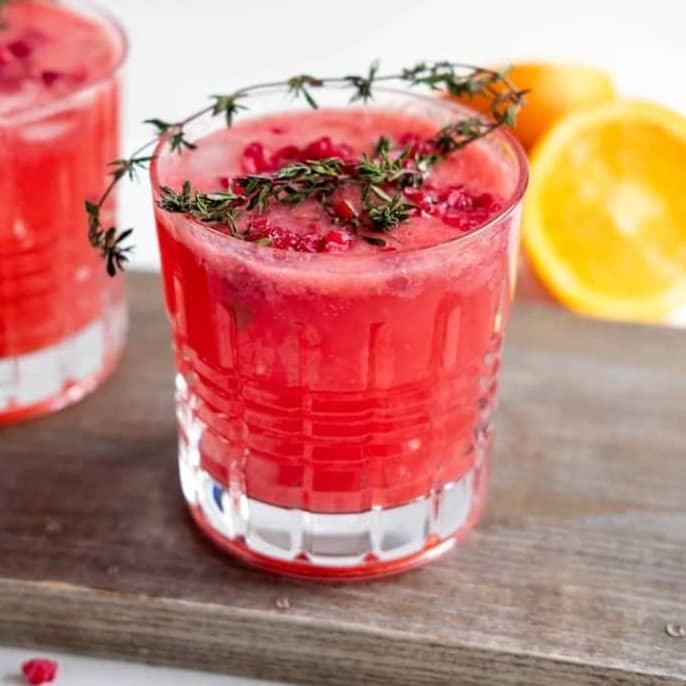 clear drinking glass with red liquid and sliced lemon