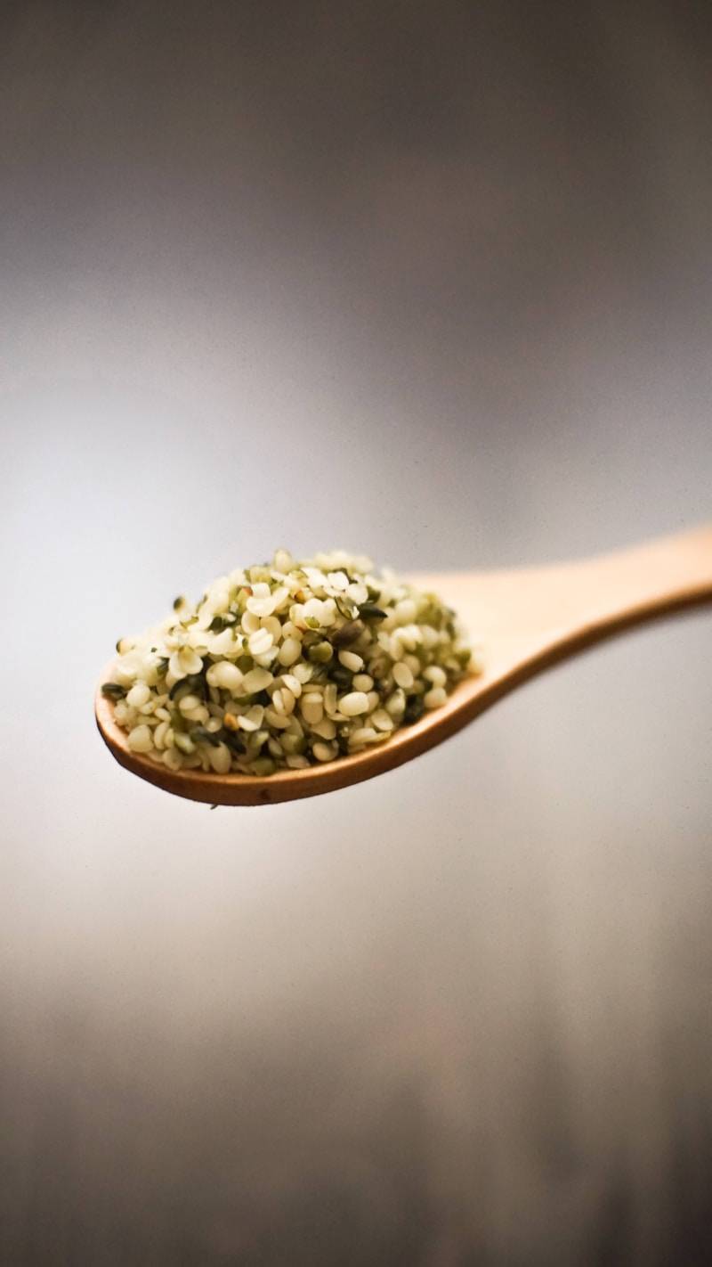 a wooden spoon filled with green food on top of a table