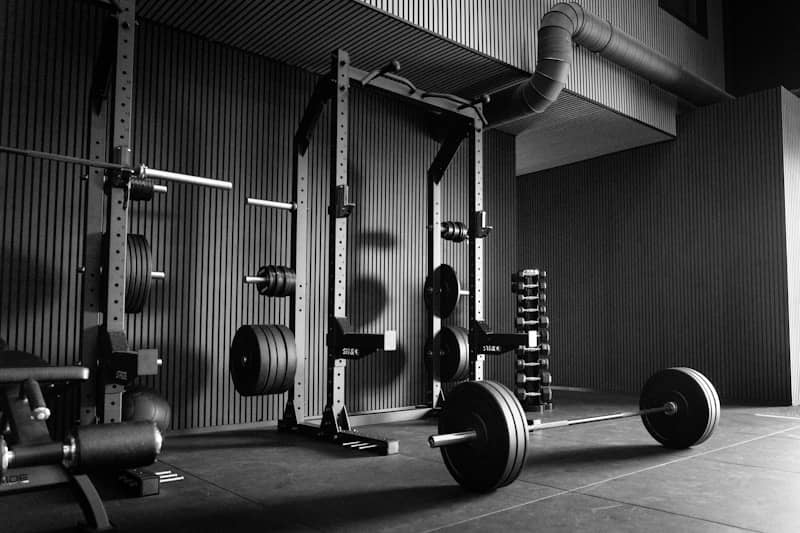 Empty gym with power rack, barbells, and weights.