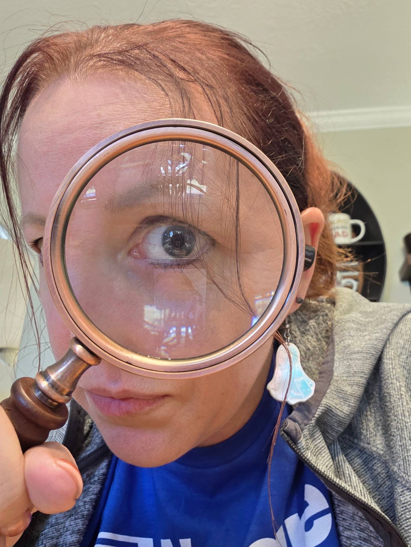 A woman looking at the camera through an old fashioned magnifying glass