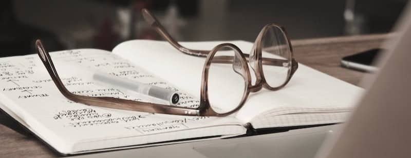 eyeglasses with gray frames on the top of notebook