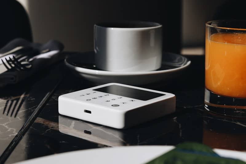 A cell phone sitting on top of a table next to a plate of food