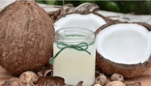 2 halved coconuts and a jar with coconut milk in it