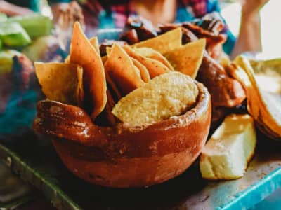 bowl of tortilla chips with other ingredients in the background